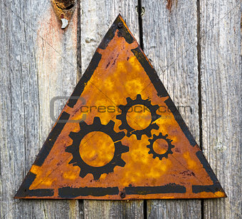 Cogwheel Gear Icon on Rusty Warning Sign.