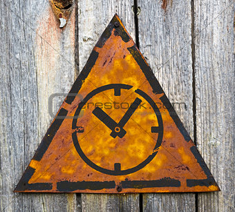 Icon of Clock Face on Rusty Warning Sign.