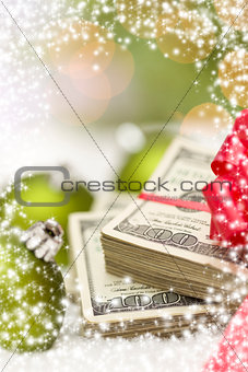 Stack of Hundred Dollar Bills with Bow Near Christmas Ornaments