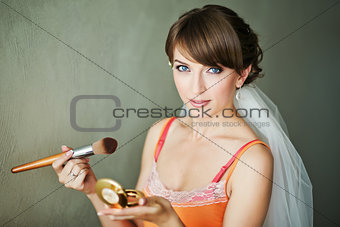bride doing make-up in the morning.