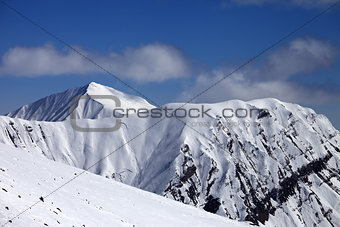 Off-piste slope with stones and mountains with trace of avalanch