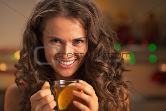 Portrait of happy young woman with cup of ginger tea