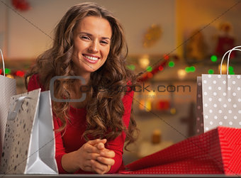 Happy young woman with shopping bags in christmas decorated kitc