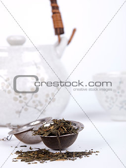 Pot of tea with fresh tea over a white background