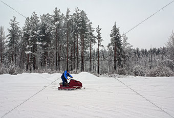 Man on a snowmobile on a skiing run.