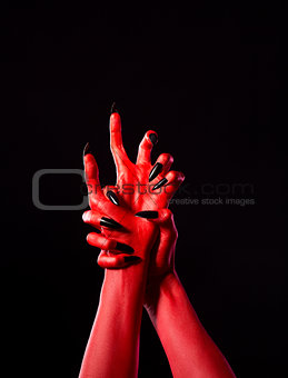 Red demonic hands with black nails, real body-art 