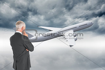 Composite image of thoughtful businessman standing back to camera