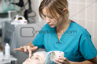 Nurse in a skin clinic applying protective cream
