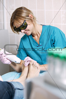 Podiatrist doing a foot laser treatment