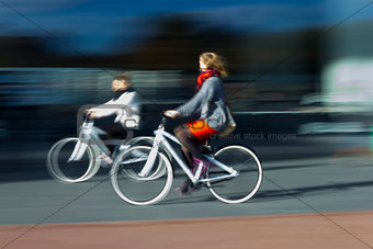 two women on the blurred bikes in profile