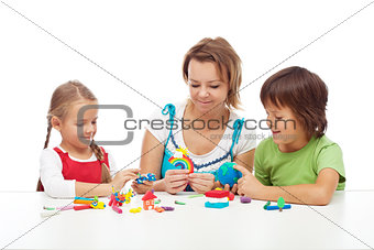 Woman and kids playing with colorful clay