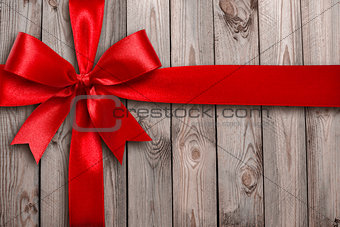 Red ribbon on a wooden background