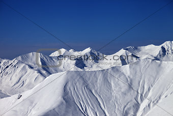 Off-piste slope with traces of skis and snowboards in nice day