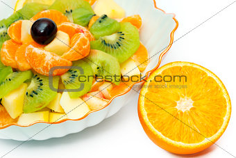 Fruit salad in vase and orange