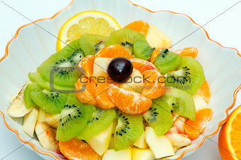 Fruit salad in vase and orange