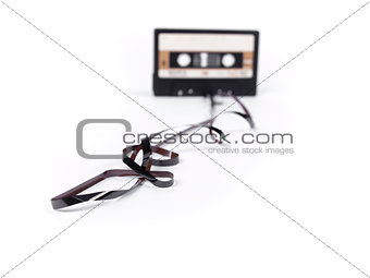 retro cassette with loose tape over a white background