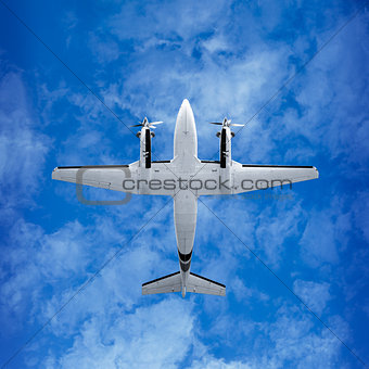 Bottom view - twin prop airplane on sky background