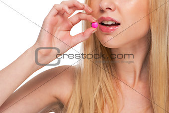 Closeup on teenage girl eating pill