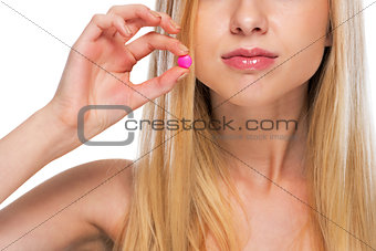 Closeup on teenage girl showing pill