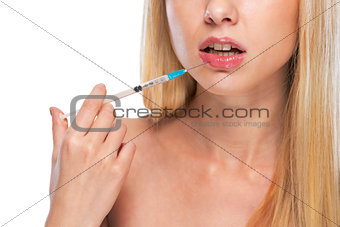 Closeup on teenage girl making lips injection