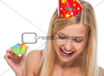Portrait of smiling teenage girl in cap with party horn blower