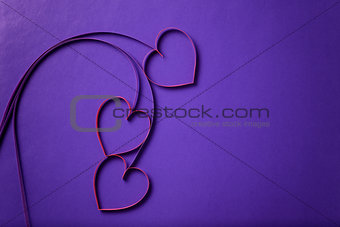 paper flowers with hearts on purple background