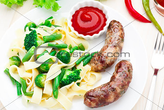 Fettuccine with vegetables and fried sausages
