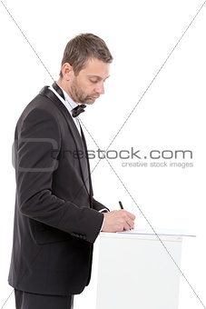 Man in a bow tie completing a form
