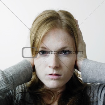 Young woman blocking her ears