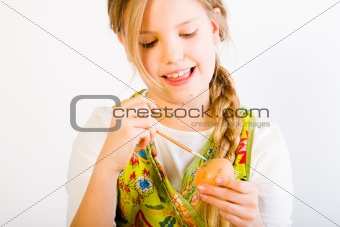 Young girl having fun painting eggs for easter
