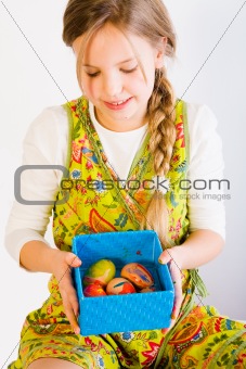 Young girl looking at a box with easter eggs