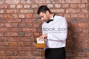 Man reading a document from a wooden box