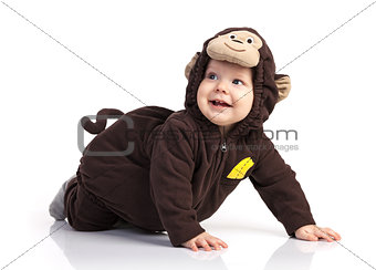 Cute baby boy in monkey costume looking up over white