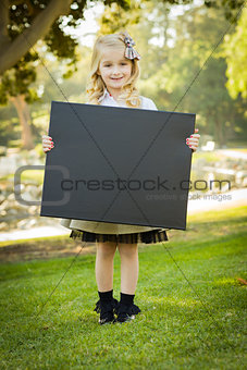 Cute Little Blonde Girl Holding a Black Chalkboard Outdoors 