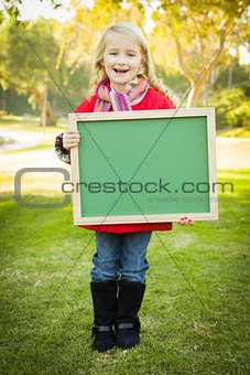 Cute Girl Holding a Green Chalkboard Wearing Winter Coat Outdoor
