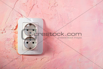 White socket on pink wall