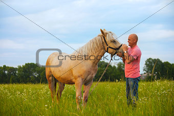 a man walks with his horse
