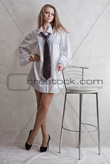 Young sexy girl the blonde with a bar chair