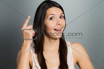 Young woman raising her index finger