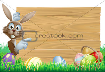Easter bunny pointing at sign
