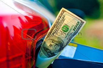 Hundred dollar bills in a vehicle fuel tank neck