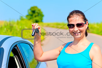 young woman proudly displays the keys to her new car