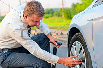 businessman pumps car tire pump