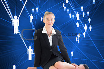 Composite image of young businesswoman sitting on ground