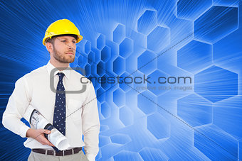 Composite image of young architect posing with hard hat and plan