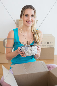 Woman unwrapping boxes in new house