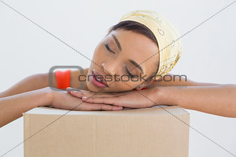Pretty young woman resting head over boxes