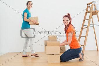 Portrait of two friends moving together in a new house
