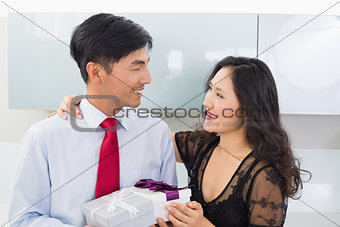 Couple with gift box in the kitchen at home