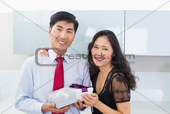 Portrait of a couple with a gift box in kitchen